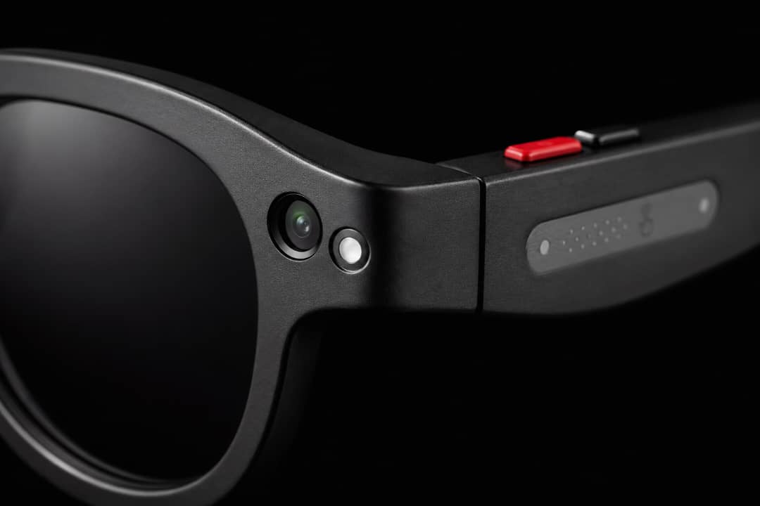 Gros plan AiMB-S1 — caméra 2MP, flash, bouton tactile et microphone sur la branche noire