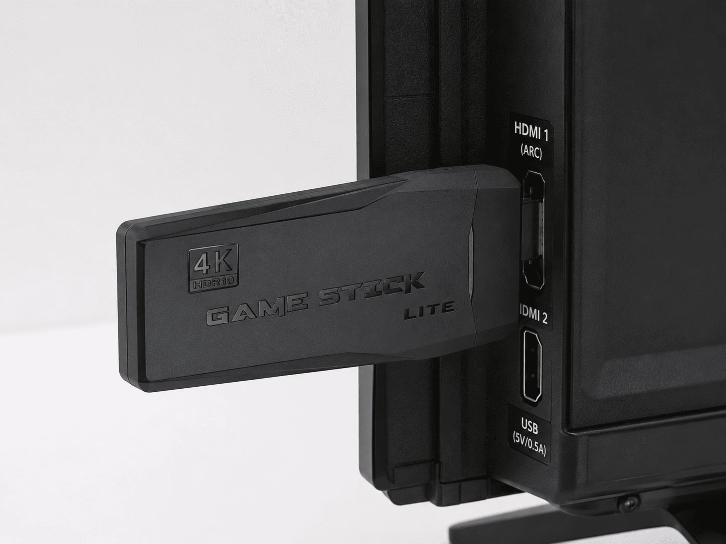 Gros plan de la console Game Stick Lite 4K branchée sur port HDMI de TV